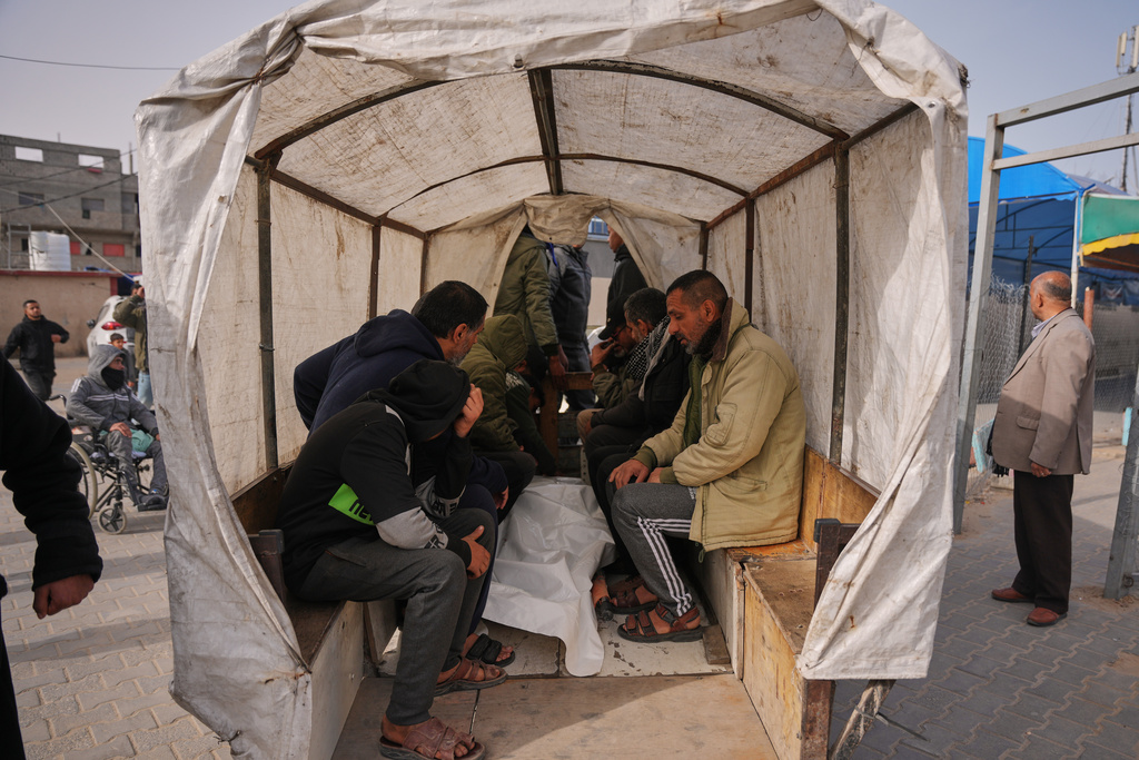 Palestinians mourn over the body of a person who was killed in an Israeli strike, as they sit on a cart during his funeral outside at Al-Aqsa Hospital in Deir al-Balah, central Gaza Strip, Friday, Jan. 30, 2026. (AP Photo/Abdel Kareem Hana)