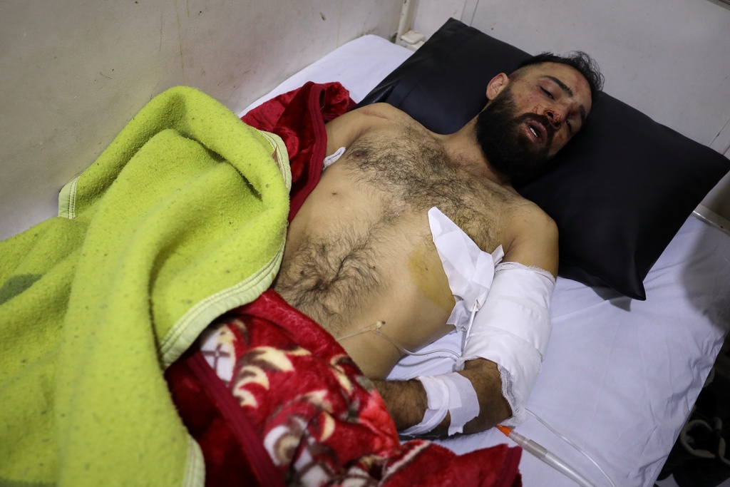 A man injured during clashes between Alawite protesters from the Alawite religious minority and counterprotesters lies in a hospital bed, two days after a bomb in an Alawite mosque in Homs killed eight people and wounded 18 during Friday prayers, in Latakia, Syria's coastal region, Sunday, Dec. 28, 2025. (AP Photo/Omar Albam)