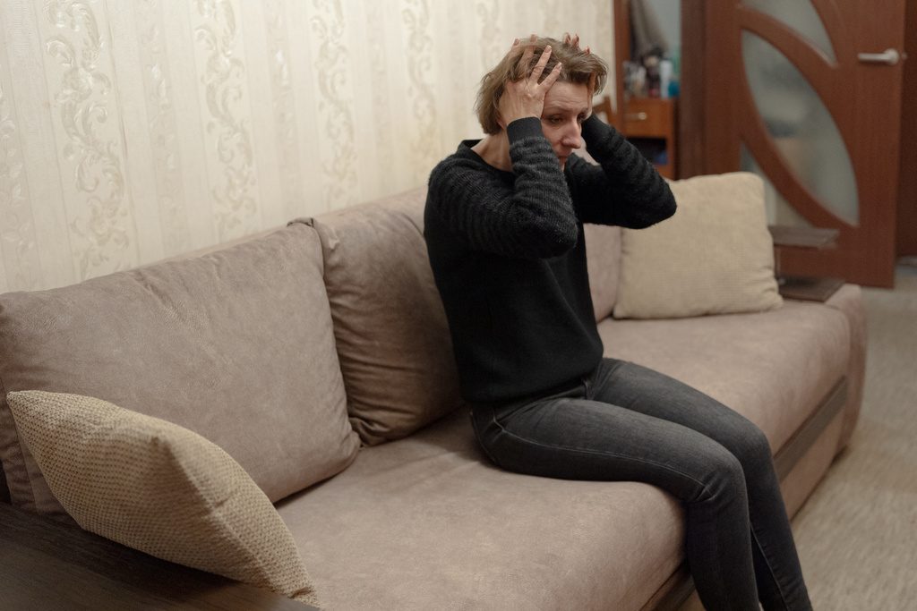 Liudmyla, the wife of Chernihiv Oblenergo crane operator Anatoliy Savchenko, 47, who was killed in a targeted Russian strike on Oct. 10, clutches her head, unsure of what to do at home, the apartment where she was born and has lived all her life, after work without her husband, Friday, Oct. 31, 2025, in Chernihiv, Ukraine. (AP Photo/Julia Demaree Nikhinson)