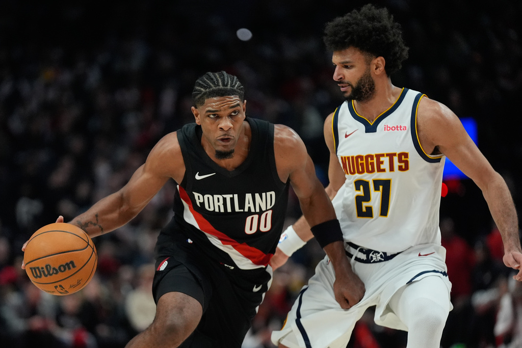 Portland Trail Blazers guard Scoot Henderson (00) drives to the basket as Denver Nuggets guard Jamal Murray (27) defends during the first half of an NBA basketball game Friday, Feb. 20, 2026, in Portland, Ore. (AP Photo/Jenny Kane)