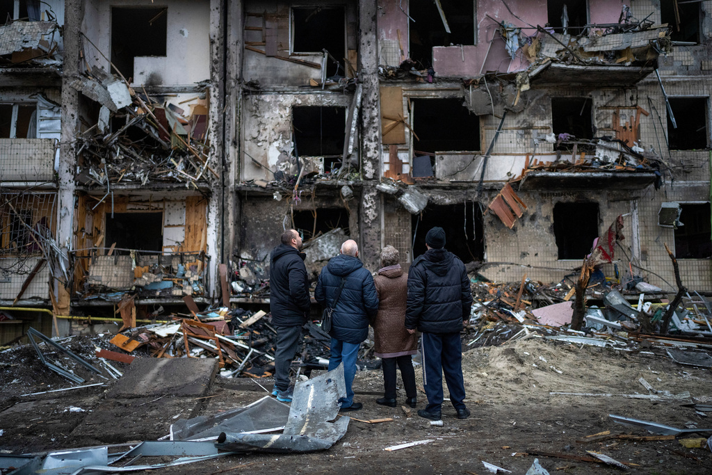 FILE- People look at the damage following a rocket attack the city of Kyiv, Ukraine, Feb. 25, 2022. (AP Photo/Emilio Morenatti, File)