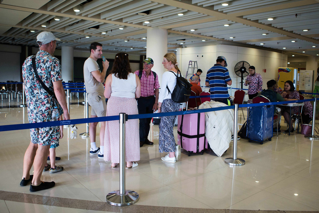 Stranded travelers queue up at an information desk as flights to the Middle East are cancelled following the attack on Iran by the U.S. and Israel, at Ngurah Rai International Airport in Kuta, Bali, Indonesia on Sunday, March 1, 2026. (AP Photo/Firdia Lisnawati)