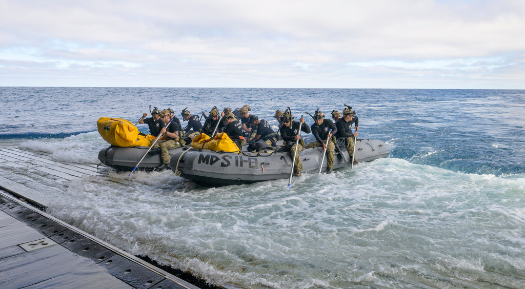 In this photo provided by NASA, U.S. Navy divers prepare to deploy in small boats from the well deck of USS John P. Murtha to recover Artemis II crew members NASA astronauts Reid Wiseman, commander; Victor Glover, pilot; Christina Koch, mission specialist; and CSA (Canadian Space Agency) astronaut Jeremy Hansen, mission specialist and NASA's Orion spacecraft in the Pacific Ocean off the coast of California, Friday, April 10, 2026. (Bill Ingalls/NASA via AP)