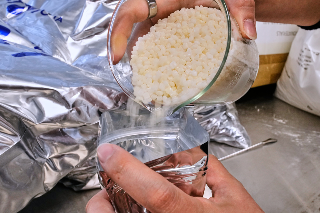 Biopolymer pellets, used in manufacturing a variety of compostable cups and utensils, is displayed at CJ Biomaterials, Monday, Aug. 3, 2026, in Woburn, Mass. (AP Photo/Charles Krupa)