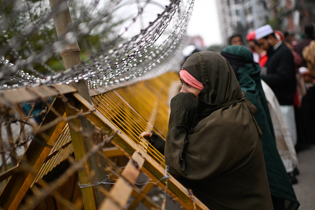 A woman reacts while waiting behind barricades outside the hospital where former Bangladeshi Prime Minister Khaleda Zia died, in Dhaka, Bangladesh, Monday, Dec. 30, 2025. (AP Photo/Mahmud Hossain Opu)