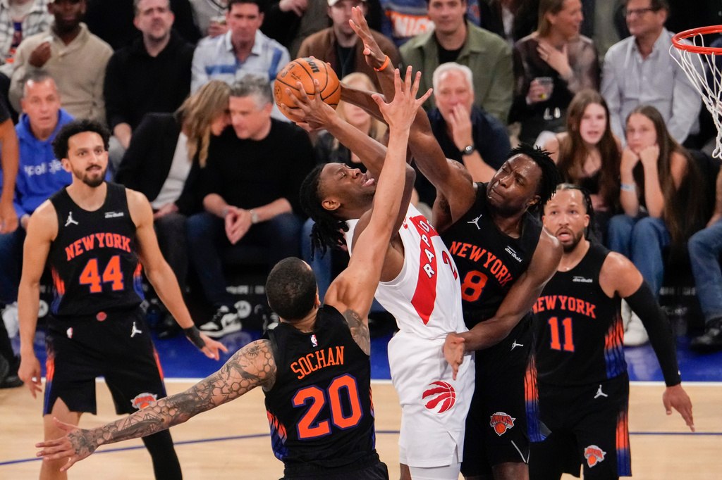 Toronto Raptors forward Jonathan Mogbo (2) shoots over New York Knicks forward Og Anunoby (8) and New York Knicks forward Jeremy Sochan (20) during the first half of an NBA basketball game, Friday, April 10, 2026, in New York. (AP Photo/Yuki Iwamura)