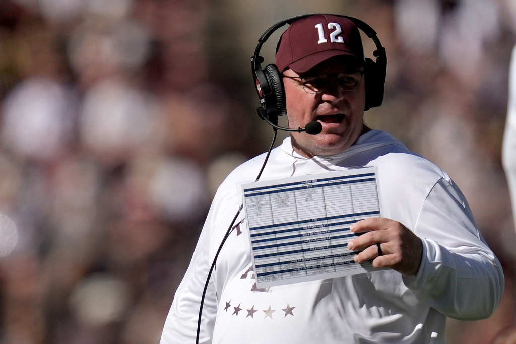 Texas A&amp;M head coach Mike Elko talks to his staff during an injury time out against Samford in the fourth quarter of an NCAA college football game Saturday, Nov. 22, 2025, in College Station, Texas. (AP Photo/Sam Craft)