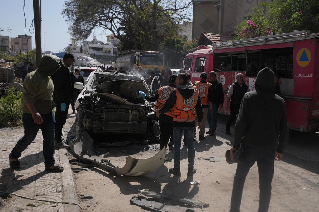 Palestinian civil defense crews work on a destroyed car after it was struck in an Israeli strike in Gaza City Tuesday, April 28, 2026. (AP Photo/Jehad Alshrafi)