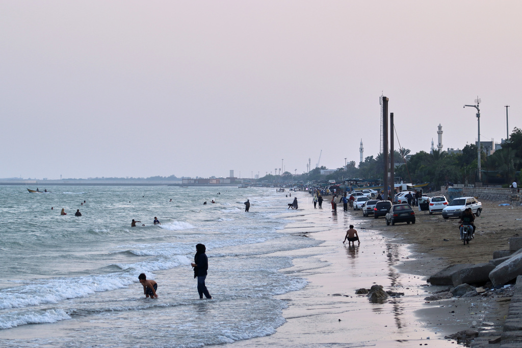 People swim and spend time along the shore of the Strait of Hormuz, off Bandar Abbas, Iran, Sunday, July 12, 2026. (Razieh Poudat/ISNA via AP)