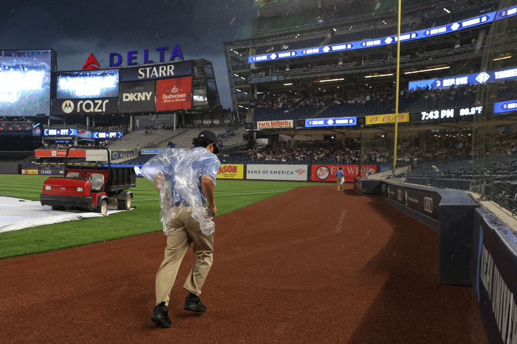 A member of the grounds crew runs during a weather delay of a baseball game between the New York Yankees and Boston Red Sox, Saturday, June 6, 2026, in New York. (AP Photo/Heather Khalifa)