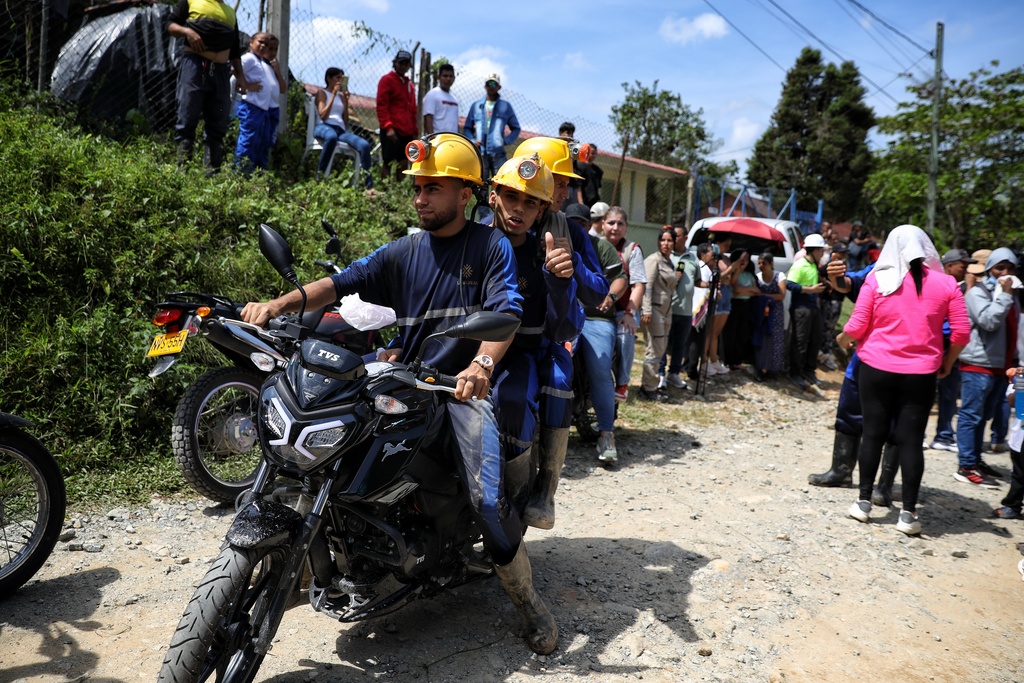 Miners ride off on a motorcycle after they were rescued from a gold mine they were working in had collapsed in Segovia, Colombia, Wednesday, Sept. 24, 2025. (AP Photo/Santiago Saldarriaga)
