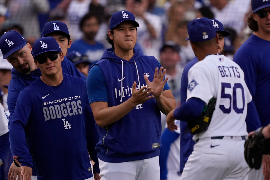 Los Angeles Dodgers' Mookie Betts, right, is congratulated by Shohei Ohtani, center, and Yoshinobu Yamamoto after the Dodgers defeated the San Francisco Giants in a baseball game Sunday, Sept. 20, 2026, in Los Angeles. (AP Photo/Mark J. Terrill)