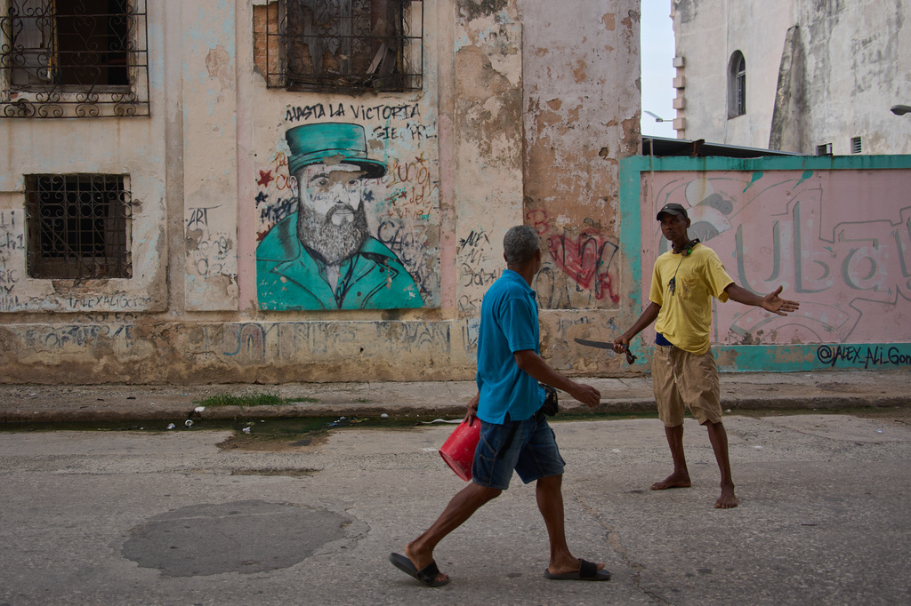 Men argue in front of a weathered mural of Fidel Castro in Havana, Cuba, Wednesday, Aug. 12, 2026. (AP Photo/Ramon Espinosa)