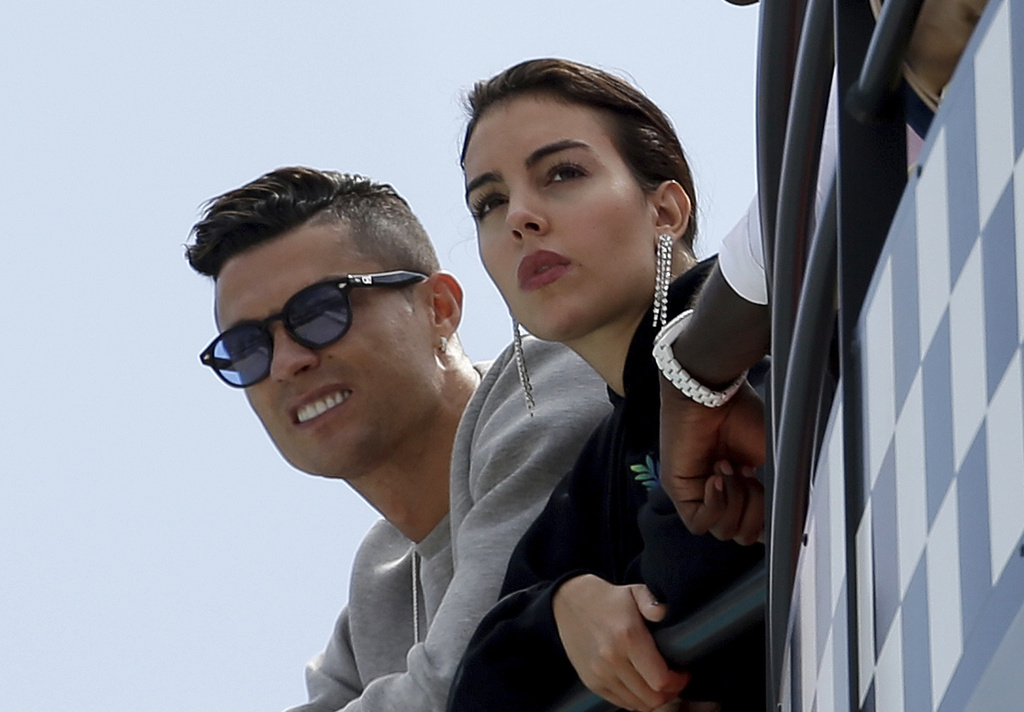FILE - Cristiano Ronaldo, left, is flanked by his partner Georgina Rodriguez as they watch the second practice session at the Monaco racetrack, in Monaco, May 23, 2019. (AP Photo/Luca Bruno, File)