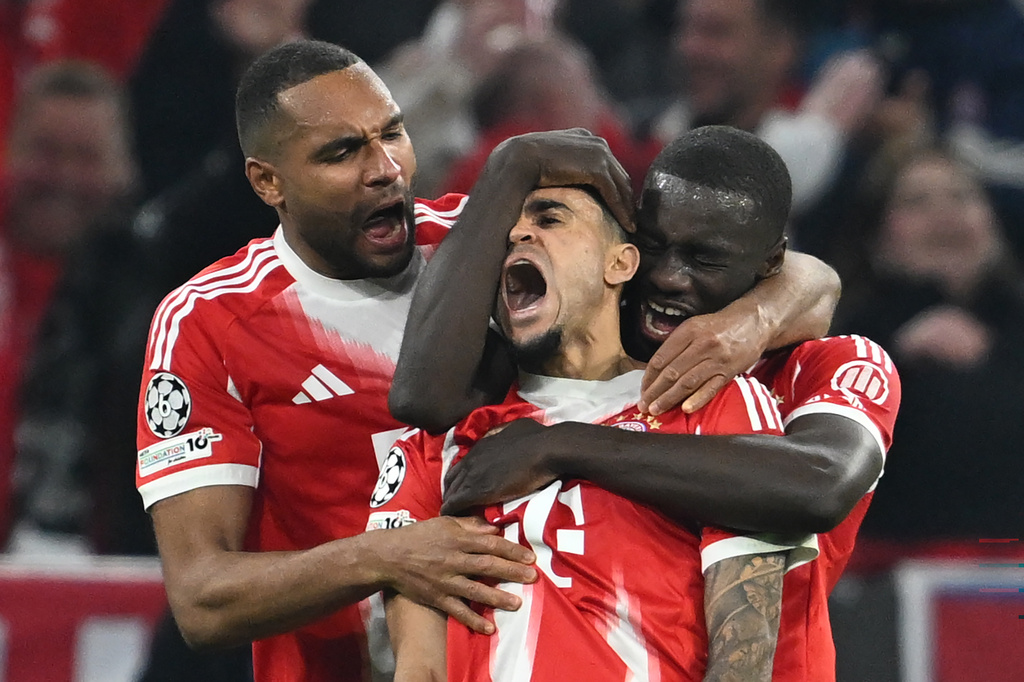 Bayern's Luis Diaz, center, celebrates with Dayot Upamecano right, and Jonathan Tah after scoring his their third goal during the Champions League quarterfinal second leg soccer match between Bayern Munich and Real Madrid in Munich, Germany, Wednesday, April 15, 2026. (Sven Hoppe/dpa via AP)