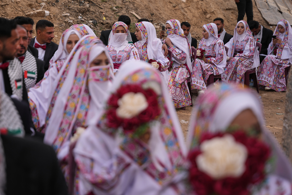 Palestinian couples participate in a mass wedding ceremony in Deir al-Balah, central Gaza Strip, Friday, April 24, 2026. (AP Photo/Abdel Kareem Hana)