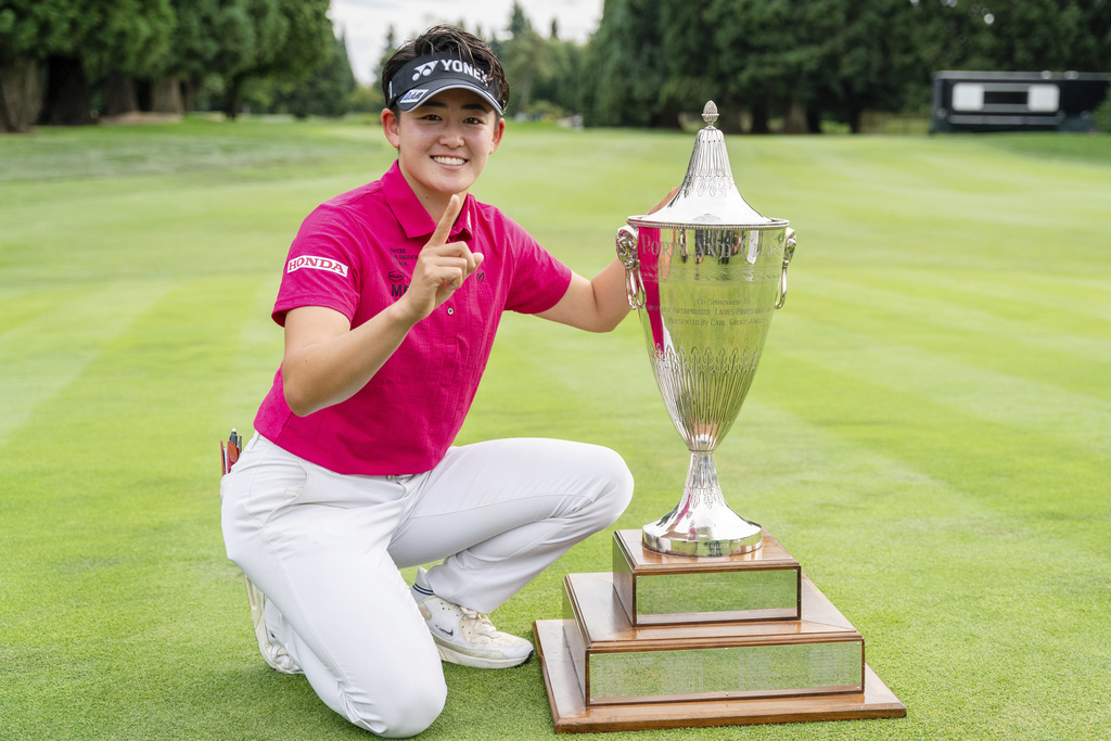 Akie Iwai, of Japan, poses with the trophy after winning the LPGA Portland Classic golf tournament at Columbia Edgewater in Portland, Ore., Sunday, Aug. 17, 2025. (AP Photo/Ali Gradischer)