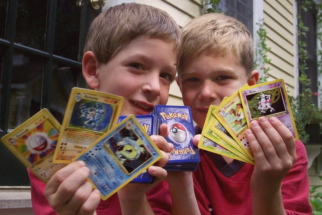 FILE - Tyler, right, and his friend George, hold up their favorite Pokemon trading cards, in Scituate, Mass., Sept. 9, 1999. (AP Photo/Charles Krupa, File)