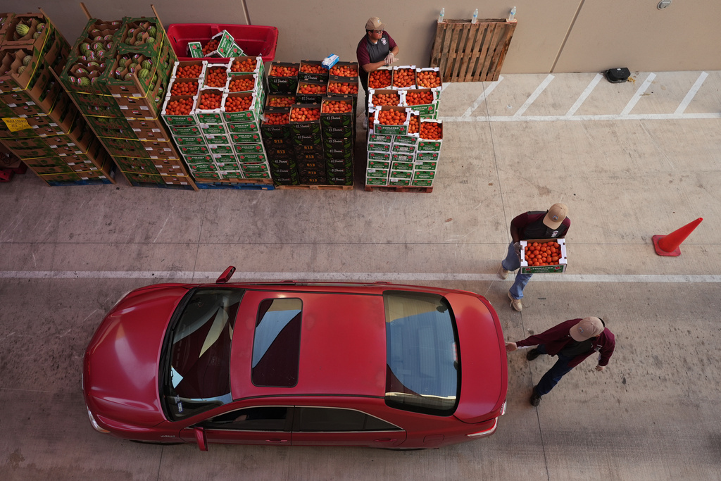 Volunteers help load vehicles during a food distribution at the San Antonio Food Bank for SNAP recipients and other households affected by the federal sutdown, Thursday, Nov. 6, 2025, in San Antonio. (AP Photo/Eric Gay)