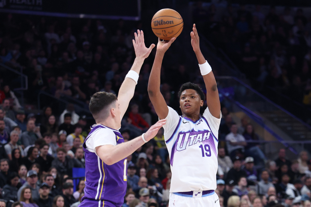 Utah Jazz guard Ace Bailey (19) looks. to shoot a 3-point basket over Los Angeles Lakers forward Jake Laravia, left, during the second half of an NBA basketball game, Thursday, Dec. 18, 2025, in Salt Lake City. (AP Photo/Rob Gray)