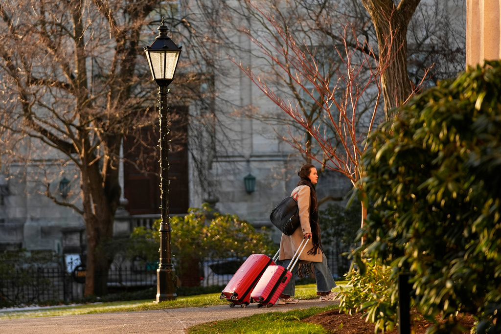 A Brown University student leaves campus, Tuesday, Dec. 16, 2025, after all classes, exams and papers were canceled for the rest of the Fall 2025 semester following the school shooting, in Providence, R.I. (AP Photo/Robert F. Bukaty)