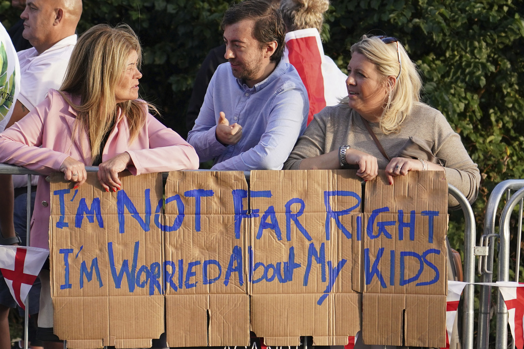 Protesters gather outside the Bell Hotel in Epping, near London, Sunday, Aug. 31, 2025 after a temporary injunction that would have blocked asylum seekers from being housed at the hotel was overturned. (AP Photo/Alberto Pezzali)