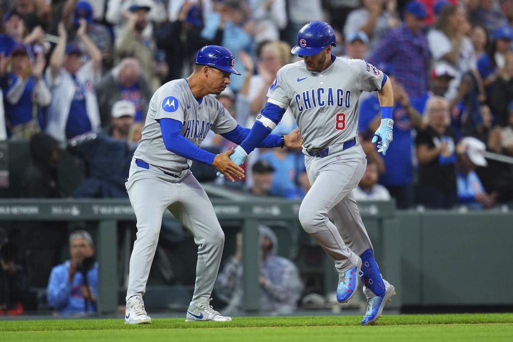 Chicago Cubs' Ian Happ (8) is congratulated by third base coach Quintin Berry, left, after hitting a. solo home run against the Colorado Rockies during the fourth inning of a baseball game Friday, Aug. 29, 2025, in Denver. (AP Photo/Jack Dempsey)