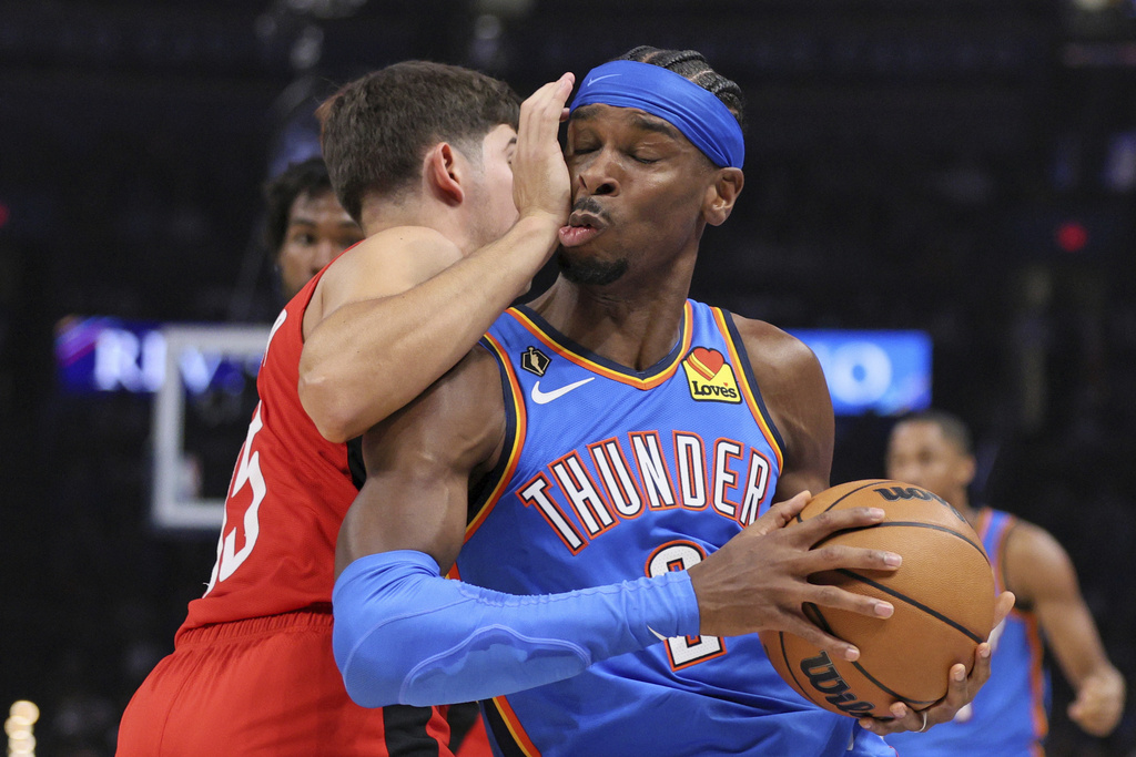 Oklahoma City Thunder guard Shai Gilgeous-Alexander, right, collides with Houston Rockets guard Reed Sheppard during the first half of an NBA basketball game Tuesday, Oct. 21, 2025, in Oklahoma City. (AP Photo/Nate Billings)