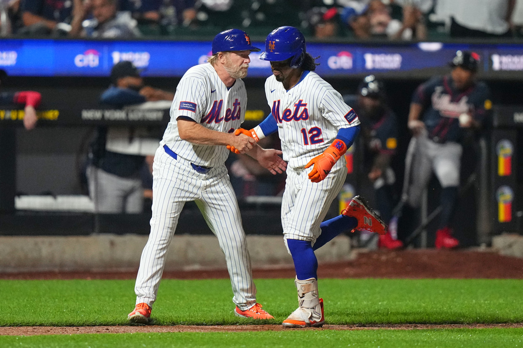 New York Mets third base coach Tim Leiper, left, celebrates with Francisco Lindor as he runs the bases after hitting a three-run home run during the eighth inning of a baseball game against the Atlanta Braves Monday, July 27, 2026, in New York. (AP Photo/Frank Franklin II)