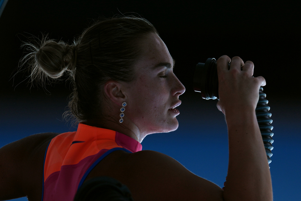 Aryna Sabalenka of Belarus blows cold air onto her face during her quarterfinal match against Iva Jovic of the U.S. at the Australian Open tennis championship in Melbourne, Australia, Tuesday, Jan. 27, 2026. (AP Photo/Dita Alangkara)