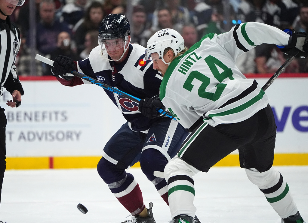 Colorado Avalanche center Brock Nelson (11) and Dallas Stars center Roope Hintz (24) fight for control of the puck in the first period of an NHL hockey game Saturday, Oct. 11, 2025, in Denver. (AP Photo/David Zalubowski)