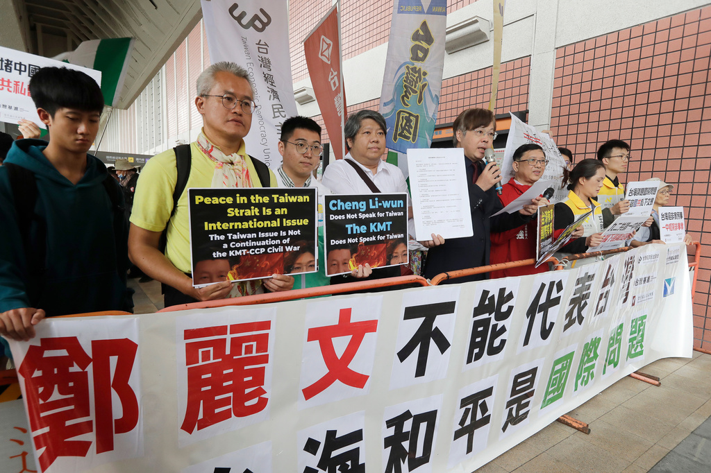 Protesters hold slogans before Taiwan's main opposition Nationalist Party, or Kuomintang (KMT) chairperson Cheng Li-wun leaves for China, outside Taipei Songshan Airport in Taipei, Taiwan, Tuesday, April 7, 2026. (AP Photo/Chiang Ying-ying)