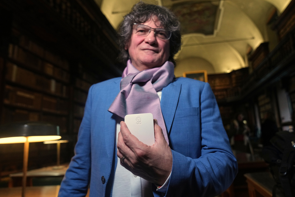 Mario Cristiani holds a device containing a digital version of a master painting from the Italian nonprofit Save the Artistic Heritage at the Brera Art Gallery in Milan, Italy, Monday, Nov. 24, 2025. (AP Photo/Antonio Calanni)