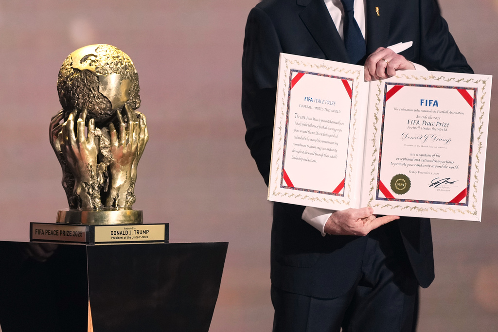 FIFA President Gianni Infantino presents President Donald Trump with the FIFA Peace Prize during the draw for the 2026 soccer World Cup at the Kennedy Center in Washington, Friday, Dec. 5, 2025. (AP Photo/Stephanie Scarbrough, Pool)
