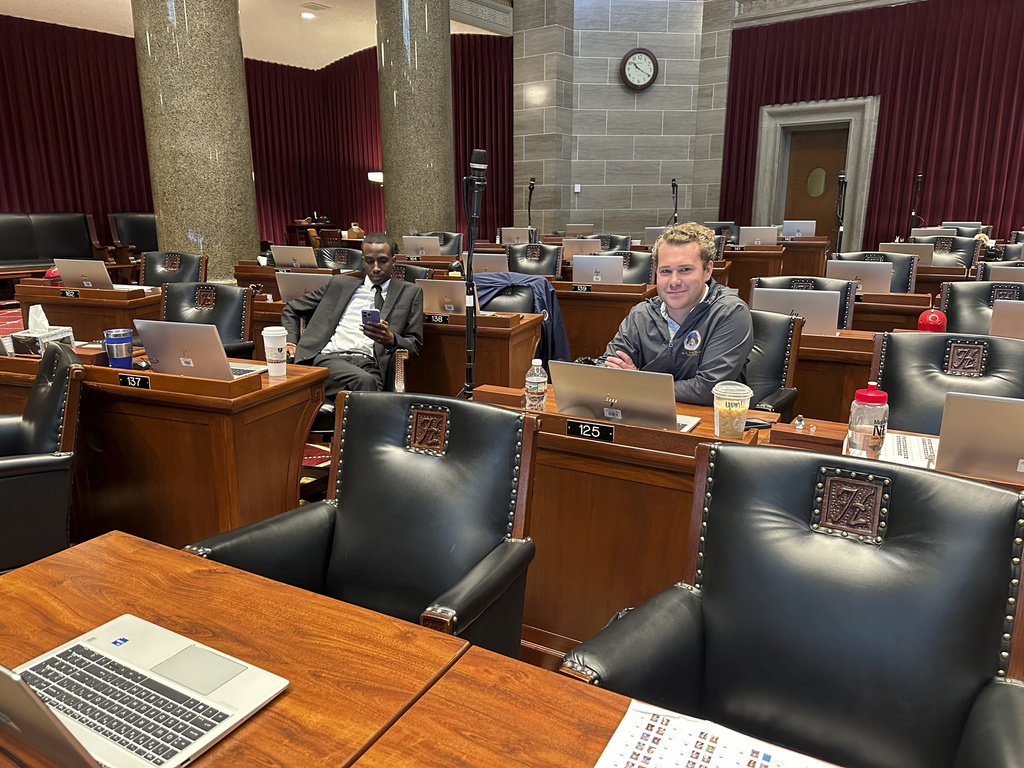 Missouri Democratic state Rep. Ray Reed, left, looks at his phone while Democratic state Rep. Jeremy Dean glances up from his computer as they wait in the Missouri House chamber during a special legislation session on Monday, Sept. 8, 2025 in Jefferson City, Mo. (AP Photo/David A. Lieb)
