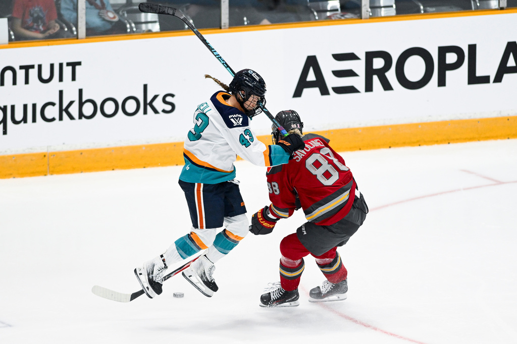 New York Sirens' Kristin O'Neill (43) jumps in front of Ottawa Charge's Ronja Savolainen (88) while trying to play the puck during third-period PWHL hockey game action in Ottawa, Ontario, Saturday, April 18, 2026. (Spencer Colby/The Canadian Press via AP)