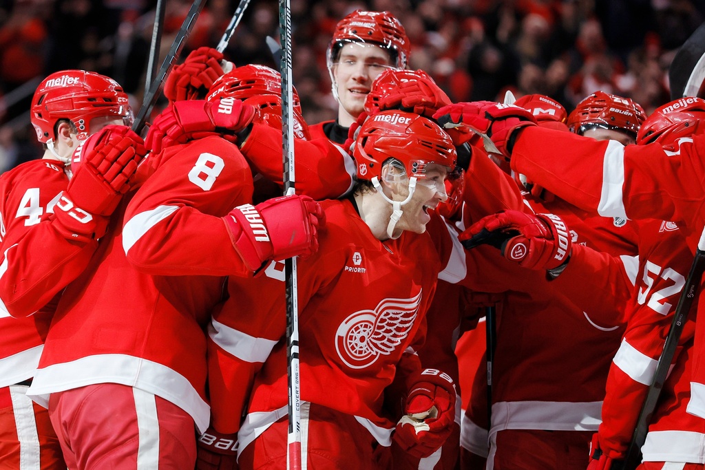 Detroit Red Wings right wing Patrick Kane, center, is surround by teammates after recording his 1,375th point to pass Mike Modano and break the NHL record for points by a player born in the United States, during the second period of an NHL hockey game Thursday, Jan. 29, 2026, in Detroit. (AP Photo/Duane Burleson)