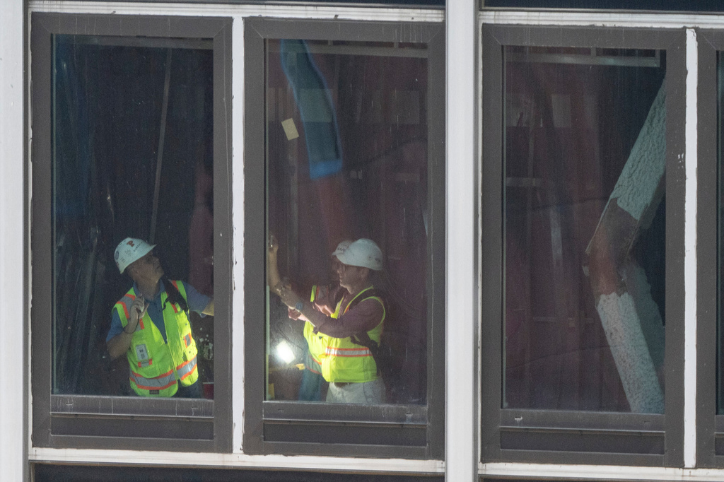 People inspect a buckled support beam inside 235 East 42nd Street, Wednesday, July 8, 2026, in New York. (AP Photo/Yuki Iwamura)