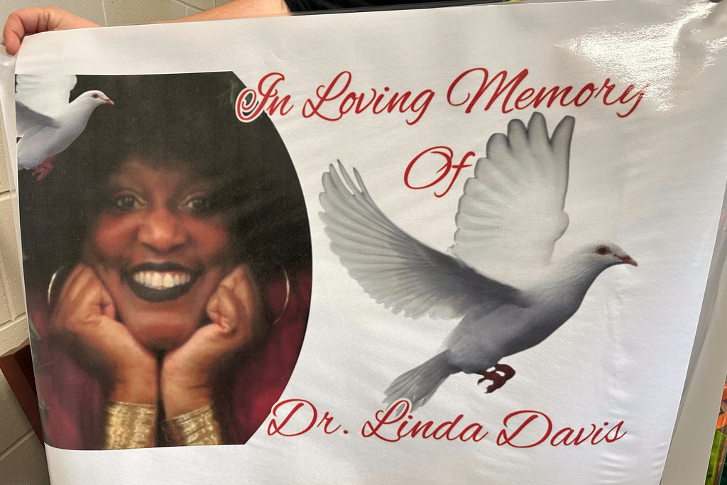 A school staff member holds a banner memorializing teacher Linda Davis at Herman W. Hesse K-8 School just outside Savannah, Ga., Thursday, Feb. 19, 2026. (AP Photo/Russ Bynum)