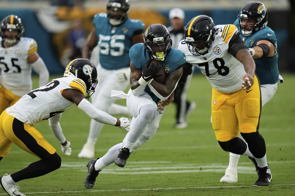 Jacksonville Jaguars running back Travis Etienne Jr. (1) runs against defensive end Yahya Black during the first half of an NFL preseason football game, Saturday, Aug. 9, 2025, in Jacksonville, Fla. (AP Photo/John Raoux)
