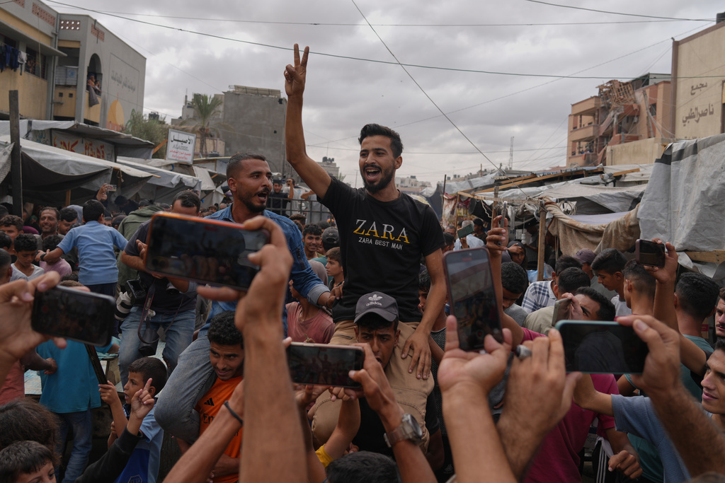 Palestinians celebrate following the announcement that Israel and Hamas have agreed to the first phase of a peace plan to pause the fighting, in Khan Younis, southern Gaza Strip, Thursday, Oct. 9, 2025. (AP Photo/Jehad Alshrafi)
