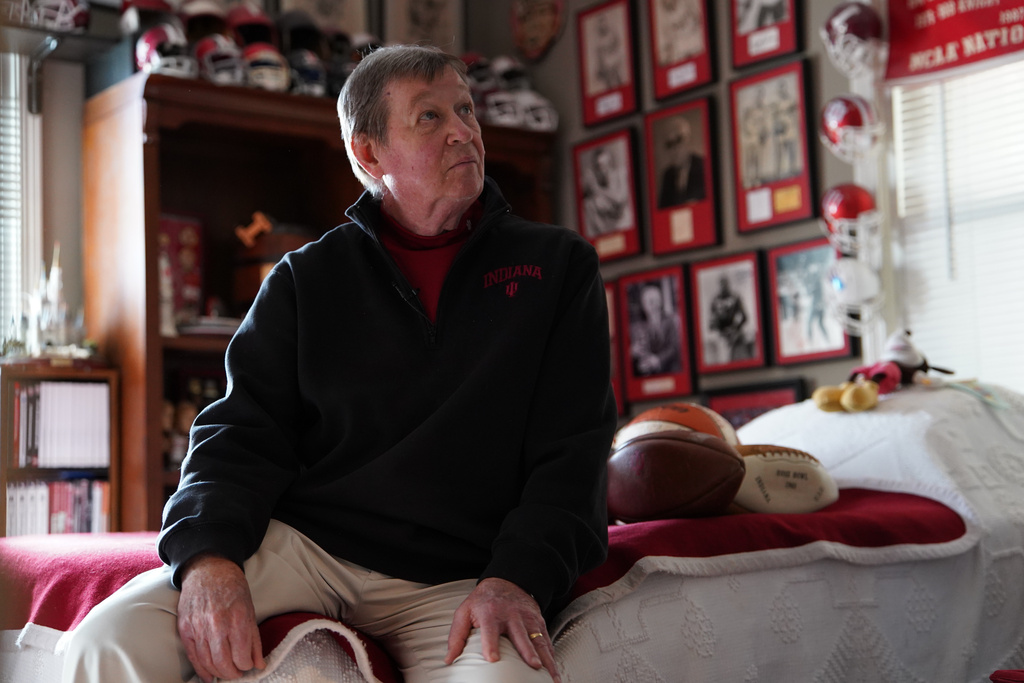 Bill Murphy sits on a bed and looks at memorabilia hanging on the wall in a room at his home in Greenfield, Ind., on Wednesday, Dec. 17, 2025. (AP Photo/Obed Lamy)