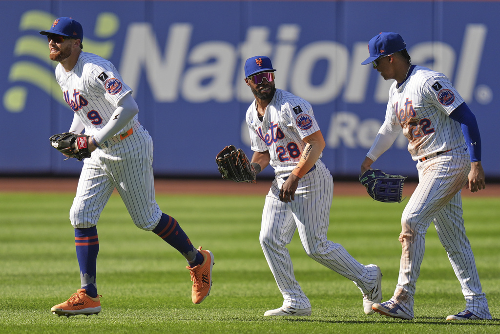 From left to right, New York Mets outfielders Brandon Nimmo, Cedric Mullins and Juan Soto celebrate after a baseball game against the San Diego Padres, Thursday, Sept. 18, 2025, in New York. (AP Photo/Seth Wenig)
