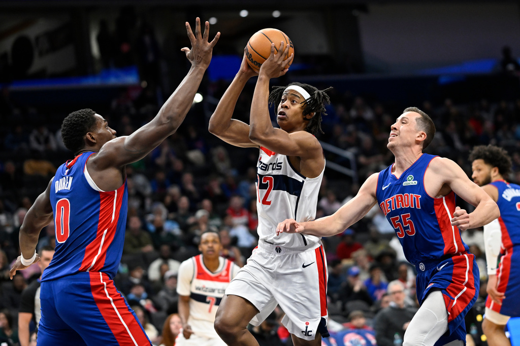 Washington Wizards guard Tre Johnson goes to shoot between Detroit Pistons center Jalen Duren (0) and Detroit Pistons forward Duncan Robinson (55) during the first half of an NBA basketball game, Tuesday, March 17, 2026, in Washington. (AP Photo/John McDonnell)