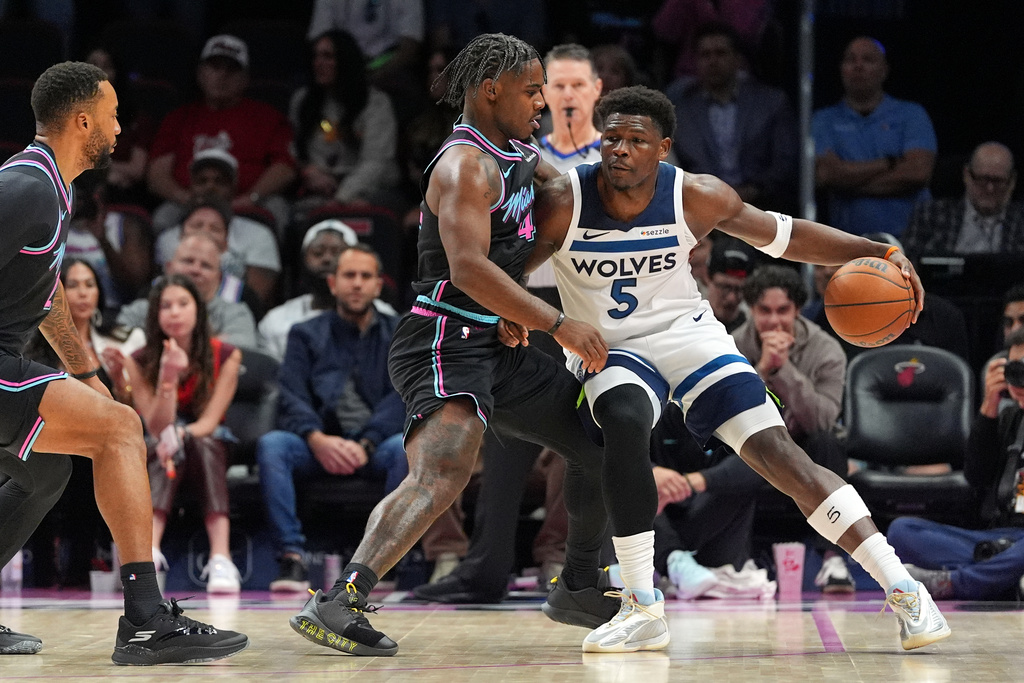 Minnesota Timberwolves guard Anthony Edwards (5) looks for an opening past Miami Heat guard Davion Mitchell (45) during the first half of an NBA basketball game, Saturday, Jan. 3, 2026, in Miami. (AP Photo/Rebecca Blackwell)