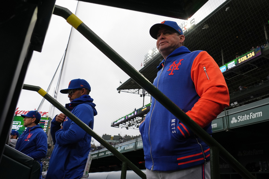 New York Mets manager Carlos Mendoza, right, watches his team during the first inning of a baseball game against the Chicago Cubs in Chicago, Sunday, April 19, 2026. (AP Photo/Nam Y. Huh)