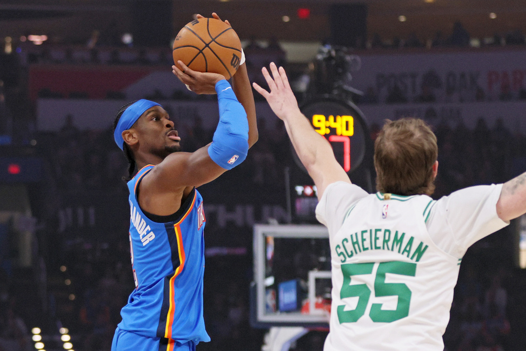 Oklahoma City Thunder guard Shai Gilgeous-Alexander, left, looks to shoot against Boston Celtics guard Baylor Scheierman (55) during the first half of an NBA basketball game, Thursday, March 12, 2026, in Oklahoma City. (AP Photo/Nate Billings)