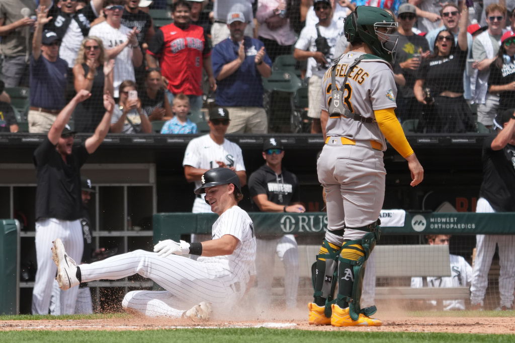 Chicago White Sox's Colson Montgomery, left, is safe at home plate as Athletics catcher Shea Langeliers, right, stands nearby during the sixth inning of a baseball game Saturday, July 11, 2026, in Chicago. (AP Photo/David Banks)