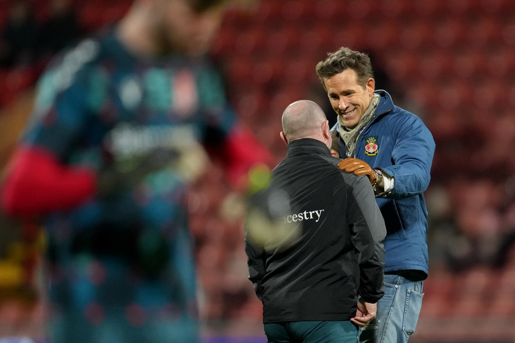 Wrexham co-owner, actor Ryan Reynolds, right, speaks with team staff prior to the English FA Cup third round soccer match between Wrexham and Nottingham Forest in Wrexham, Wales, Friday, Jan. 9, 2026. (AP Photo/Jon Super)