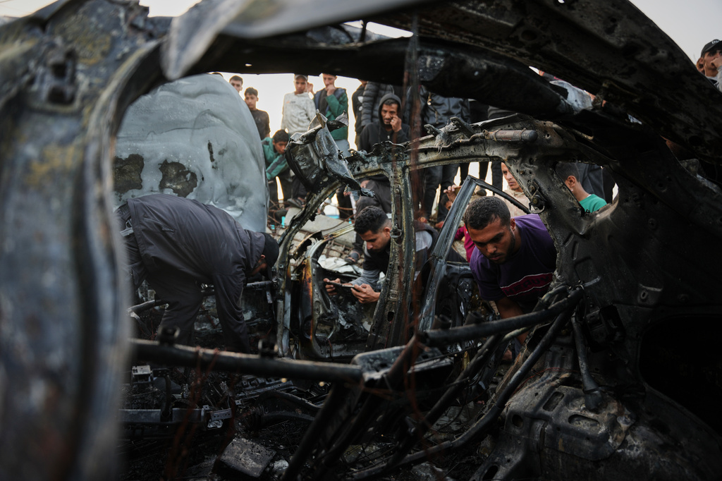 Palestinians inspect a vehicle struck by an Israeli airstrike in the Maghazi refugee camp in the central Gaza Strip, Saturday, April 4, 2026. (AP Photo/Abdel Kareem Hana)
